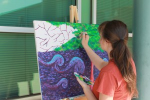 JUNIOR HANNAH HOLLOWAY works outside painting a canvas during her art class. This is her fourth art class at Northwood. Becca Heilman/The Omniscient 